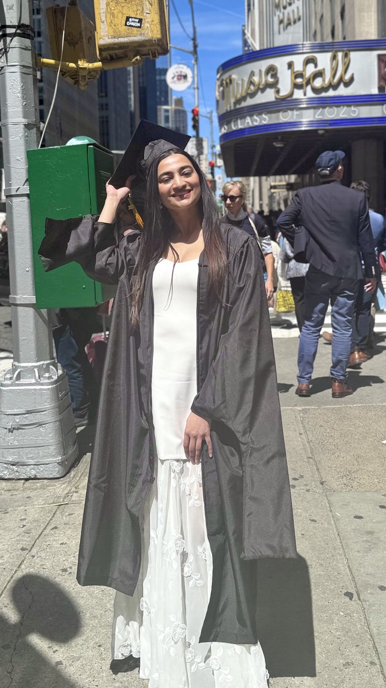 Trisha in cap and gown outside Radio City Music Hall — Pratt graduation