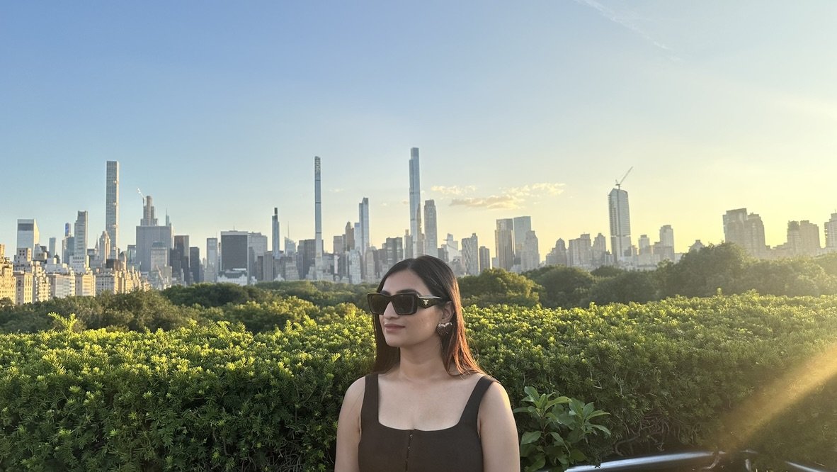 Trisha at golden hour with the New York City skyline behind her